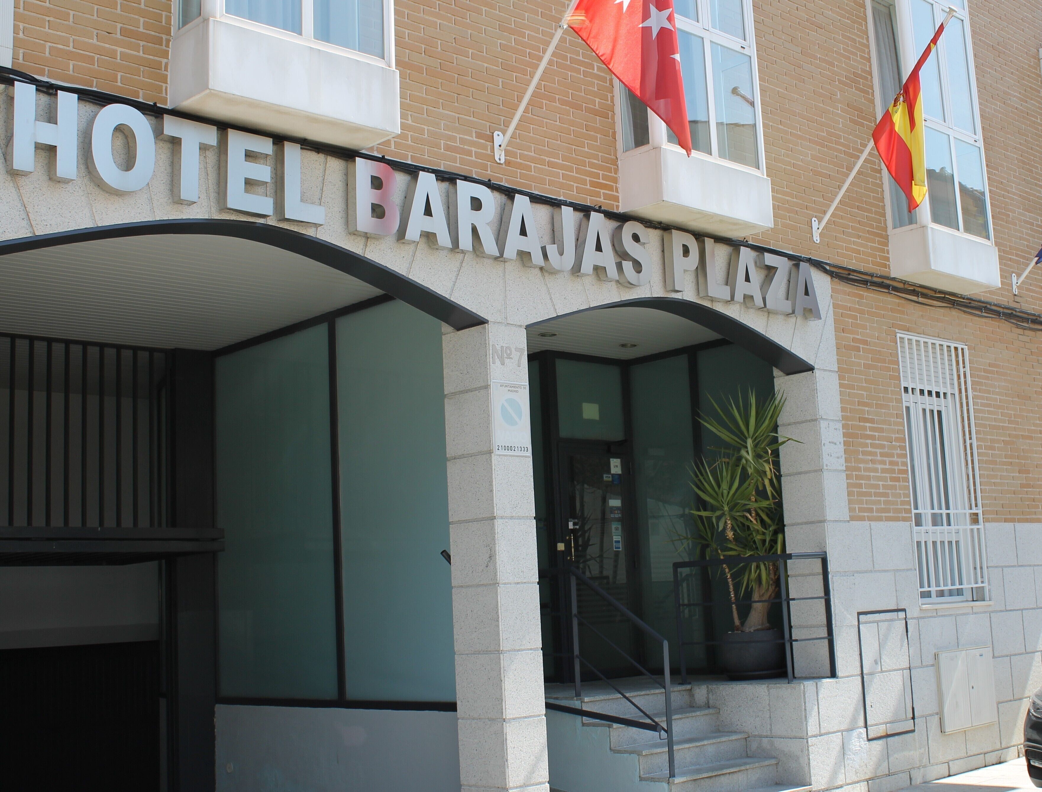 Entrada de un hotel con un letrero que dice "HOTEL BARAJAS PLAZA".