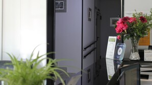 Een receptiebalie, een bloemenvaas, een bord en een deur naar een hal.