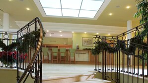 A staircase with a glass ceiling, leading to a reception area with a desk and chairs. - Dolce Villa Hotel (Prague)