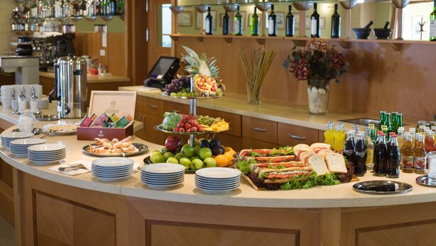 A buffet with various food items, plates, and bottles of beverages. - Dolce Villa Hotel (Prague)