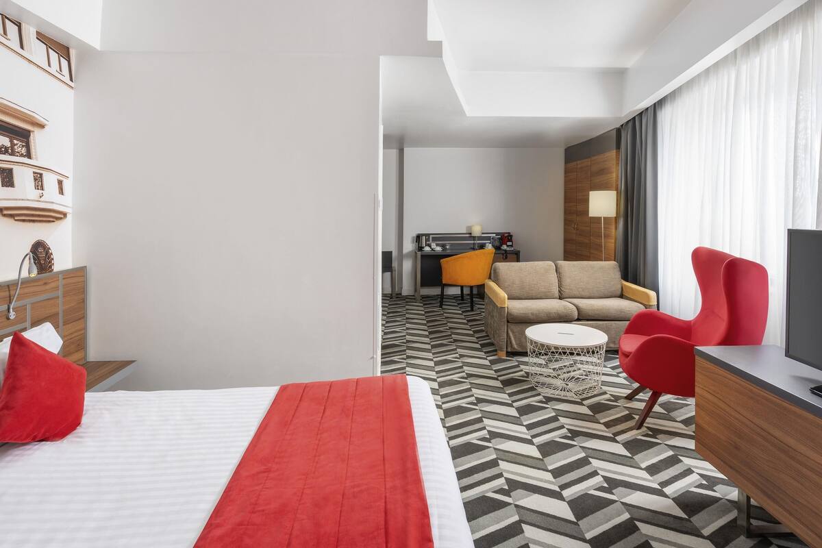 Une chambre d’hôtel équipée d’un lit, d’un canapé, d’un bureau et d’une télévision.