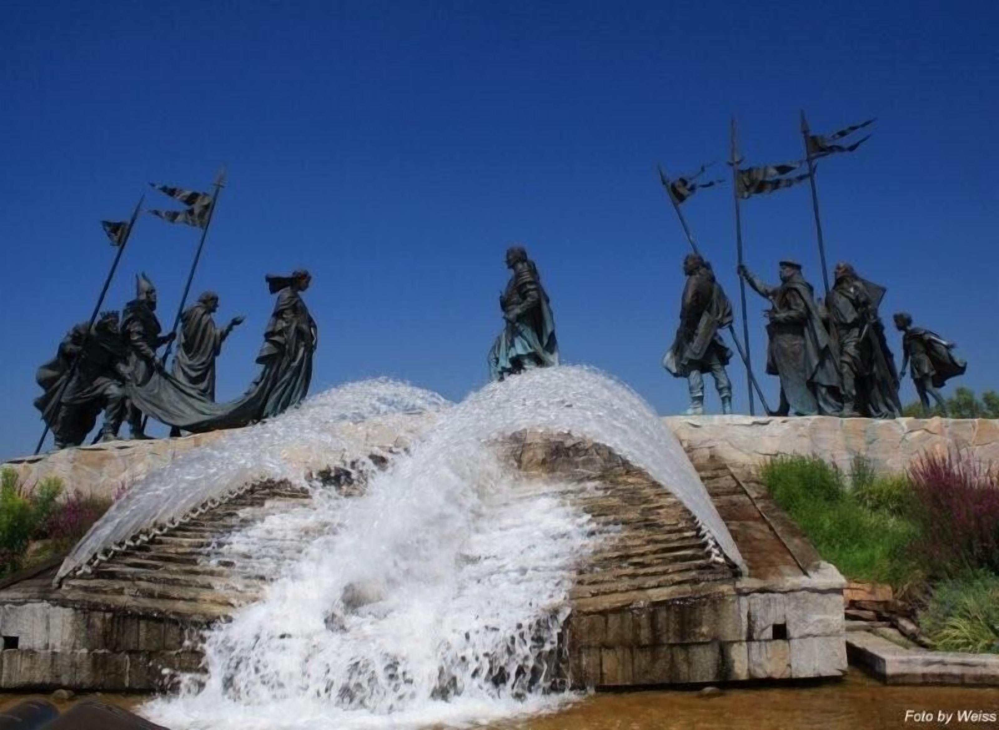 Una fuente con estatuas sobre una plataforma de piedra.