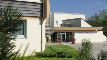 Stunning hotel building with a flat roof, surrounded by lush greenery and a beautifully manicured lawn.