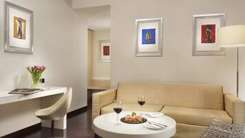 Una habitación moderna con una mesa de comedor redonda, un sofá beige y cuadros en las paredes.
