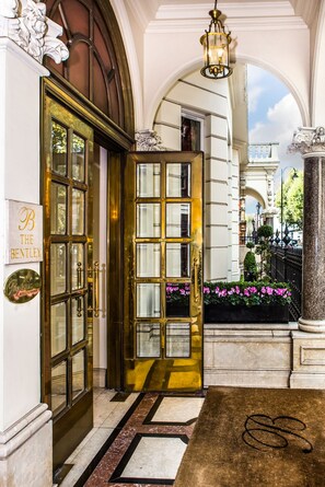 A grand entrance with a large, ornate door labeled "B The Bentley." - The Bentley London (London)