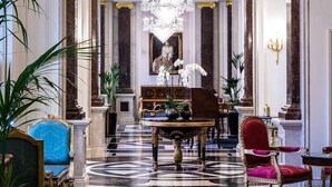 Eine prächtige Lobby mit einem großen Chandelier, Marmorböden und klassischen Säulen.