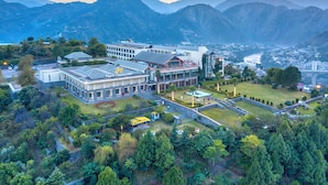 A hotel with a modern architectural design, featuring a large building with multiple floors and a prominent glass facade.