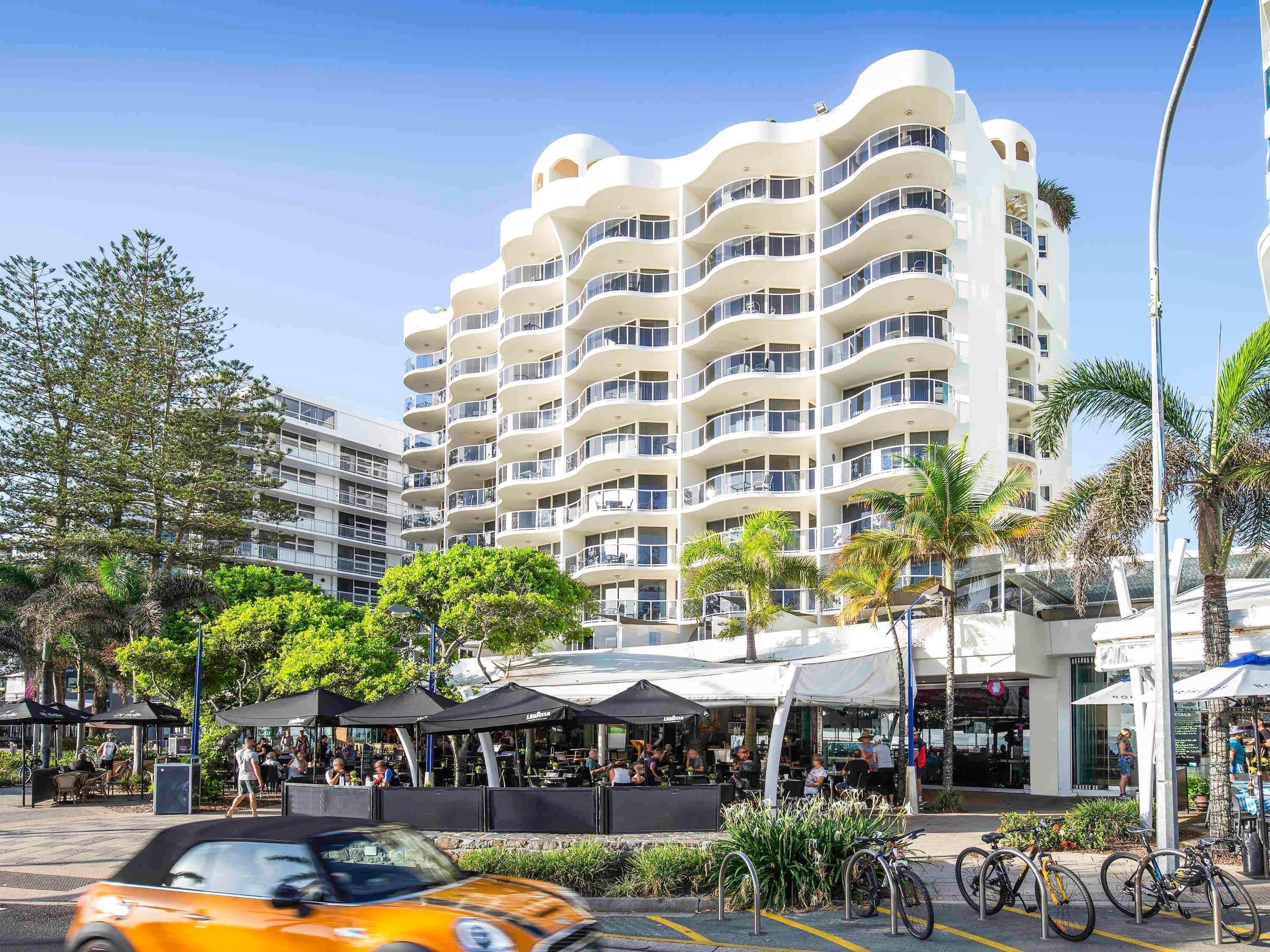 Un hôtel à plusieurs étages doté de balcons, d’un espace extérieur aménagé et de vélos à disposition.