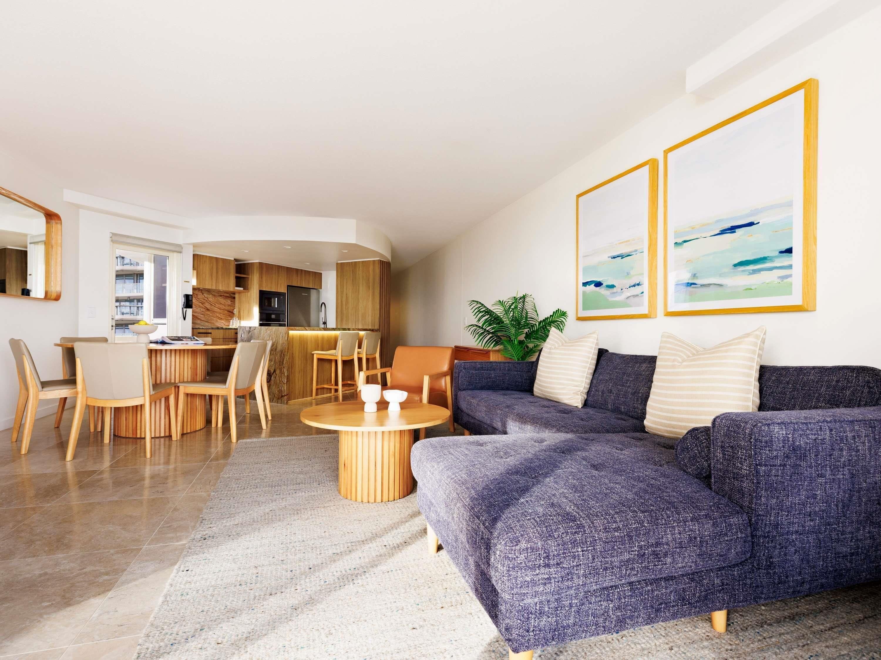 A modern living room with a sofa, coffee table, and dining area.
