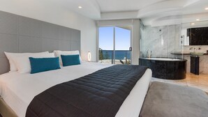 A modern bedroom with a large bed, a glass-enclosed balcony, and a separate bathroom with a bathtub. - Mantra Sirocco Resort (Mooloolaba)