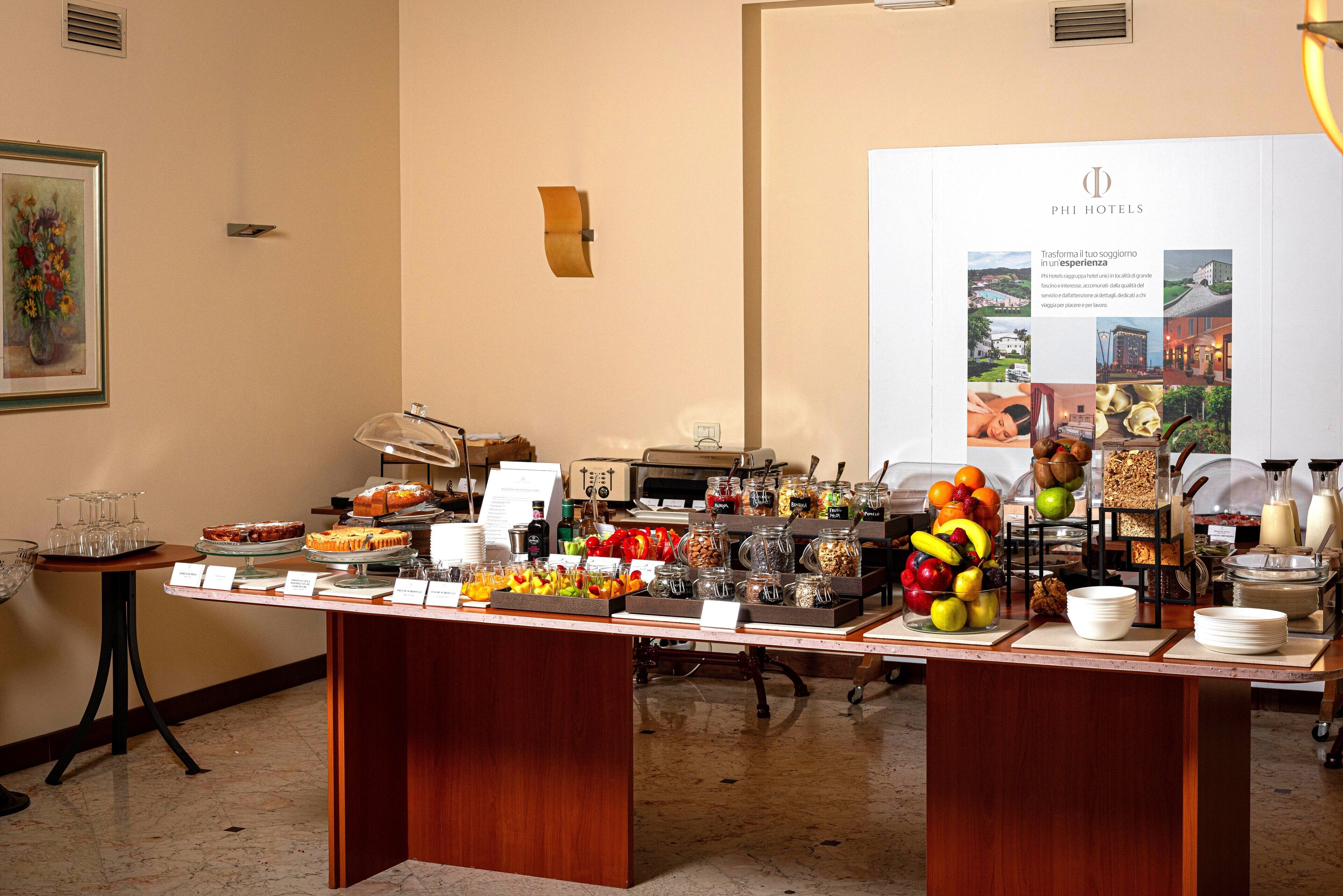 Un buffet proposant divers plats, avec, en arrière-plan, une enseigne Phi Hotels.