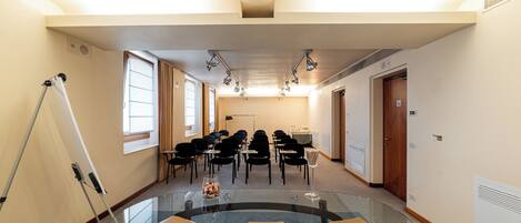 A conference room with a glass table, chairs, and a projector.