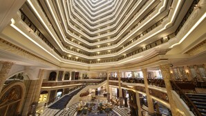 A grand hotel lobby with multiple floors, a central staircase, and ornate columns. - Legendale Hotel Beijing (Beijing)