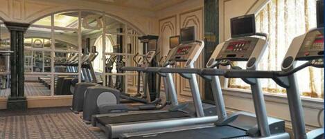A gym with treadmills, exercise bikes, and weight machines.