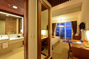 A hotel room with a bed, desk, and bathroom. - Novotel Nha Trang (Nha Trang)