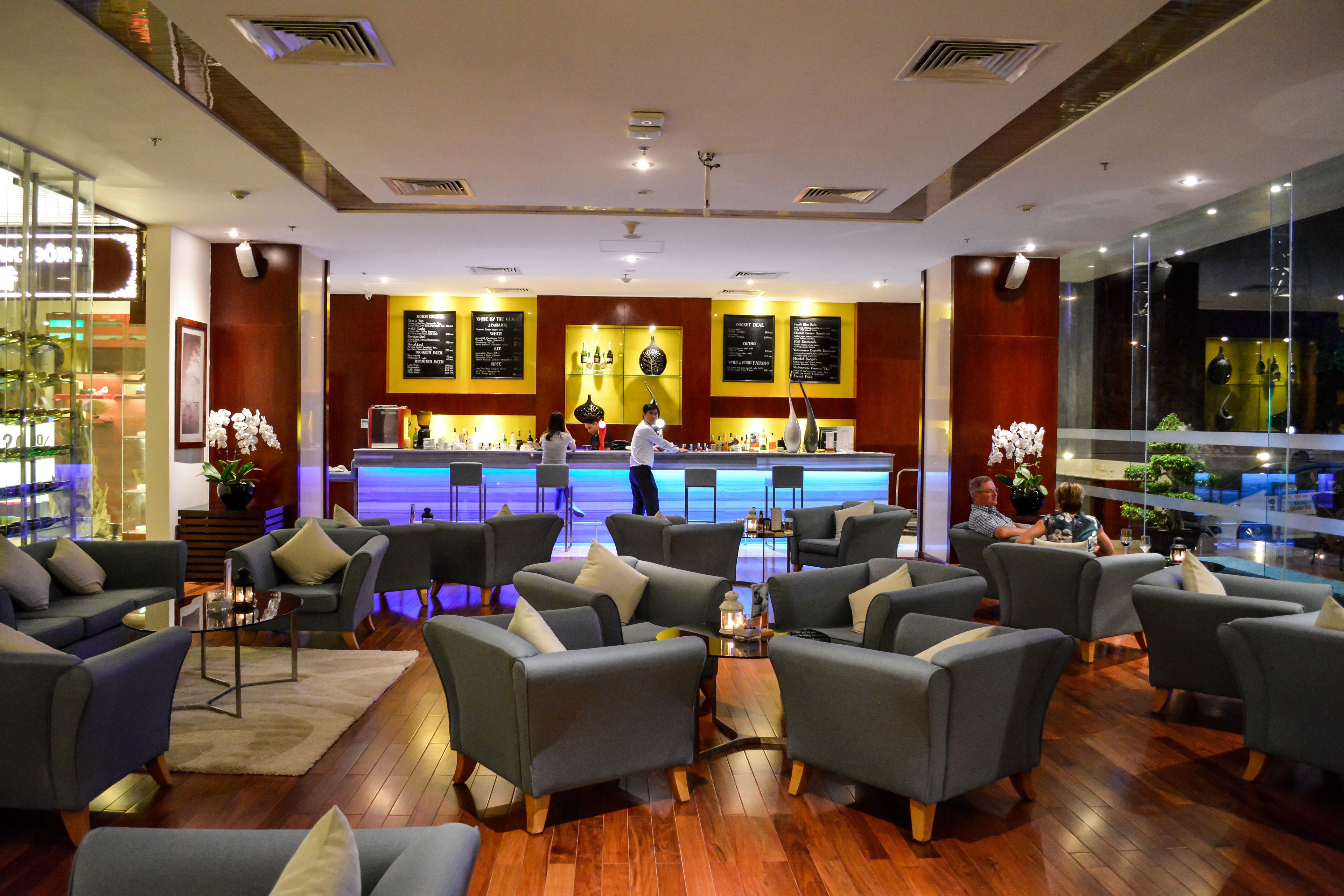 A modern lounge area with sofas and a bar counter.