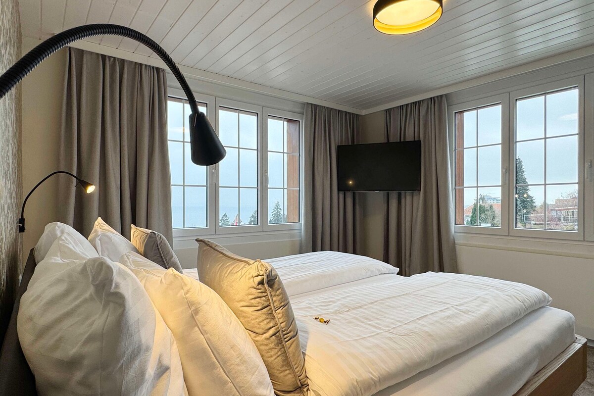 Une chambre d’hôtel avec un lit, une télévision et une fenêtre avec des rideaux.
