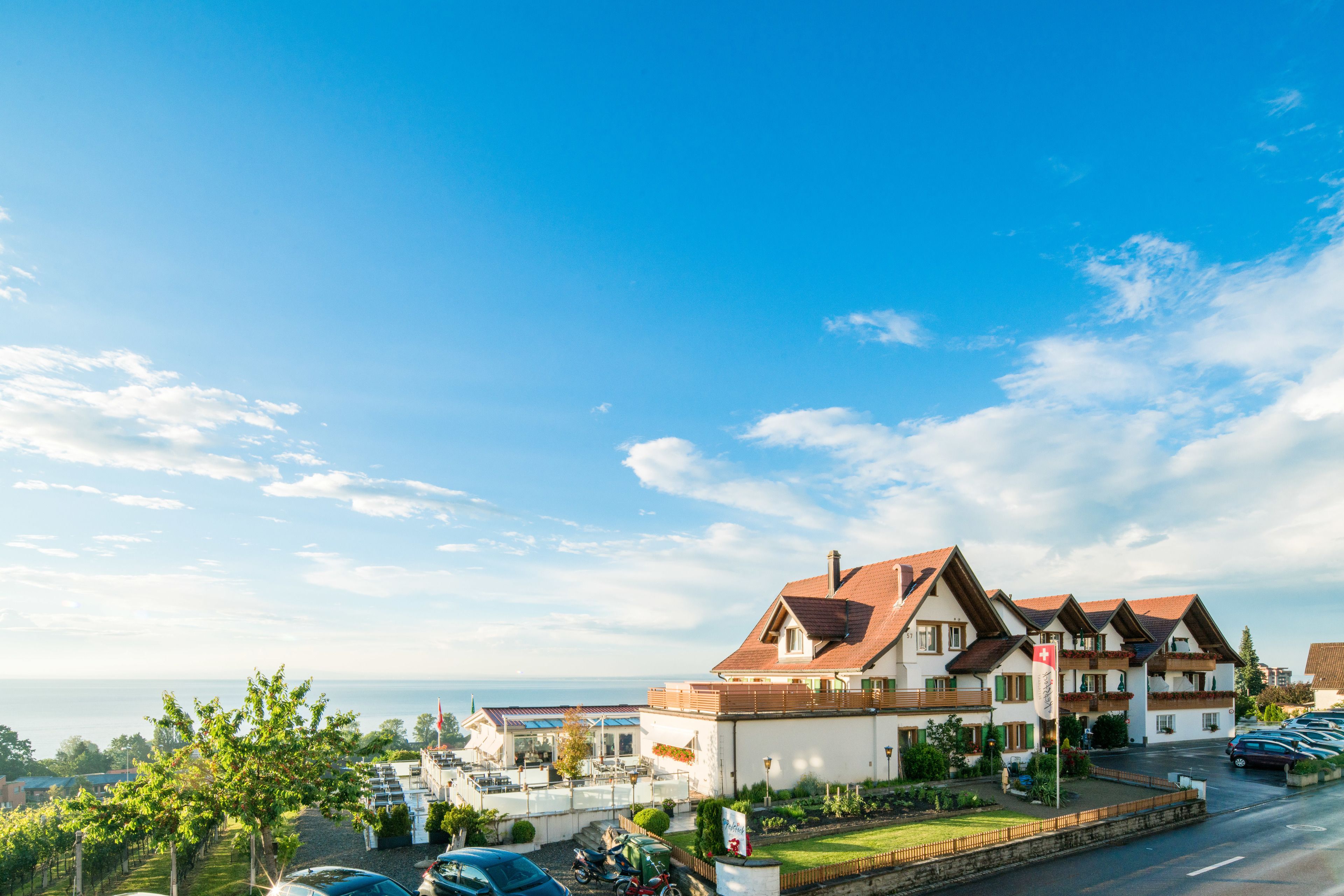 A hotel with a traditional European architectural style, featuring a prominent red roof and white walls.