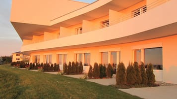 A modern multi-story building with a flat roof and large windows.