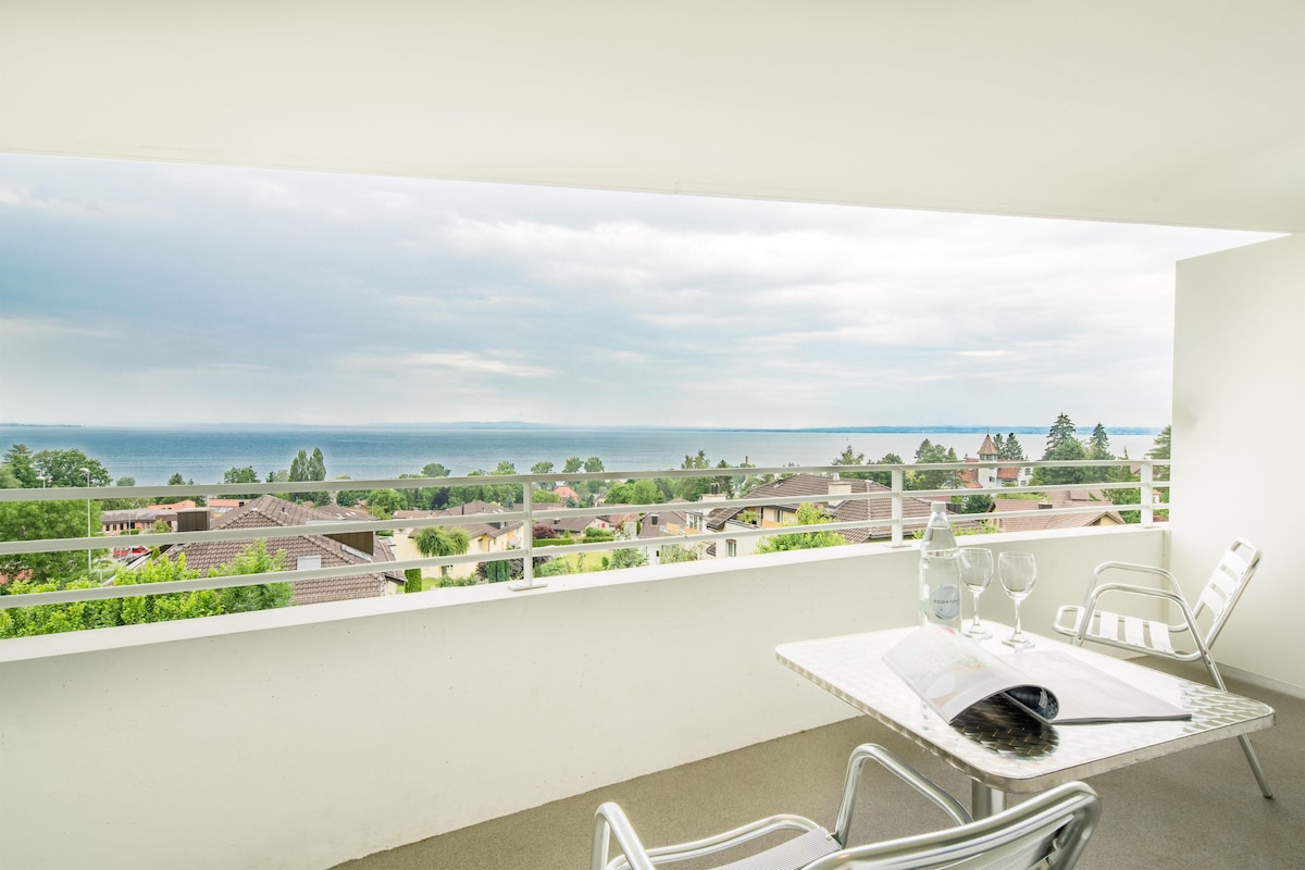 A balcony with a table, chairs, and a bottle of water.