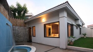 A modern house with a swimming pool, large windows, and a well-maintained lawn. - Celestia Suites at Leonia (Shamirpet)