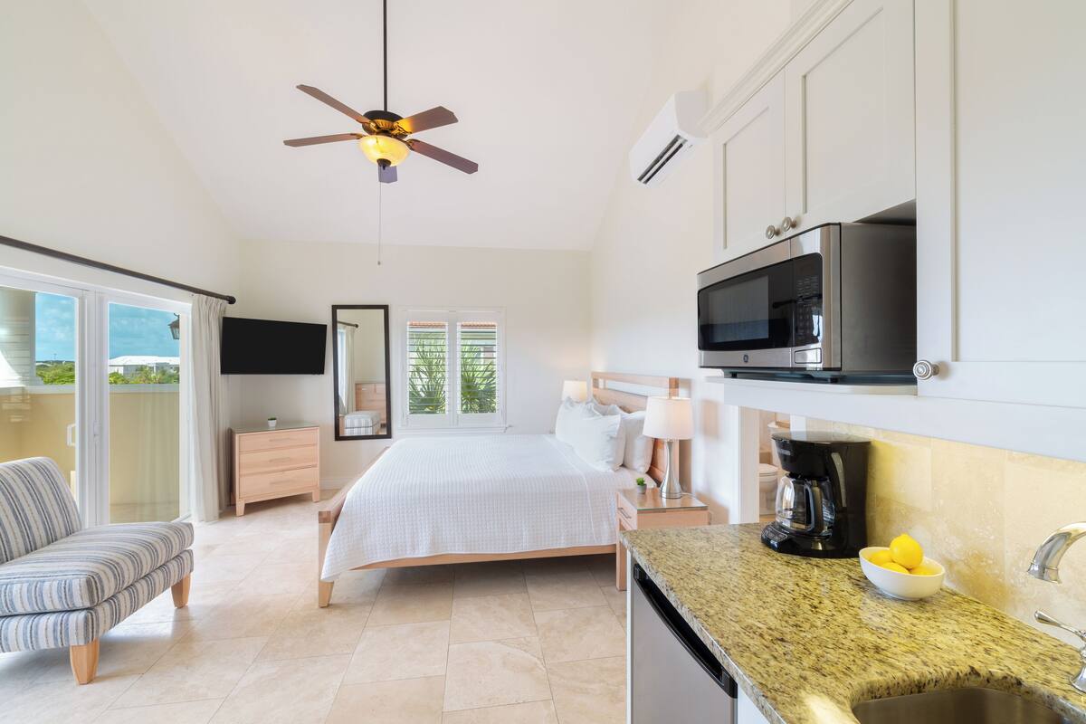 A modern bedroom with a bed, bedside table, and a ceiling fan.
