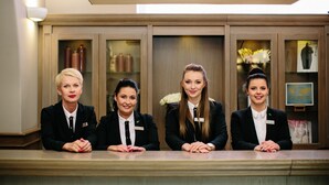 A reception desk with four staff members seated behind it. - Art Hotel (Wroclaw)