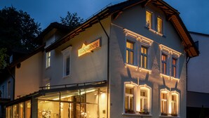 A hotel with a sign reading "Hotel Spitzberg" and a glass facade. - Hotel Spitzberg (Passau)