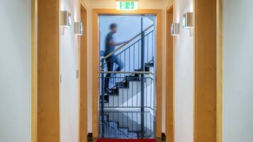 A hallway with a red carpet leading to a staircase.