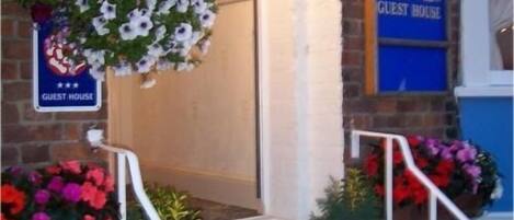 Entrada a una casa de huéspedes con un cartel que dice "The Beach View Guest House".