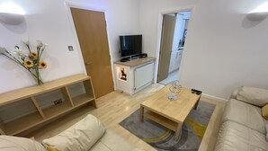 Una sala de estar moderna con un sofá, una mesa de centro y un televisor.