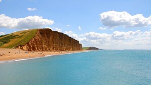 A coastal beach with cliffs and clear blue water. - Eype's Mouth Country Hotel (Bridport)