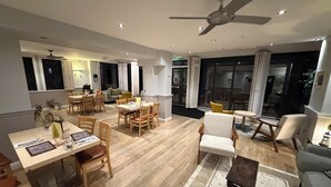 A spacious living area with a dining table, chairs, a sofa, and a ceiling fan. - Eype's Mouth Country Hotel (Bridport)
