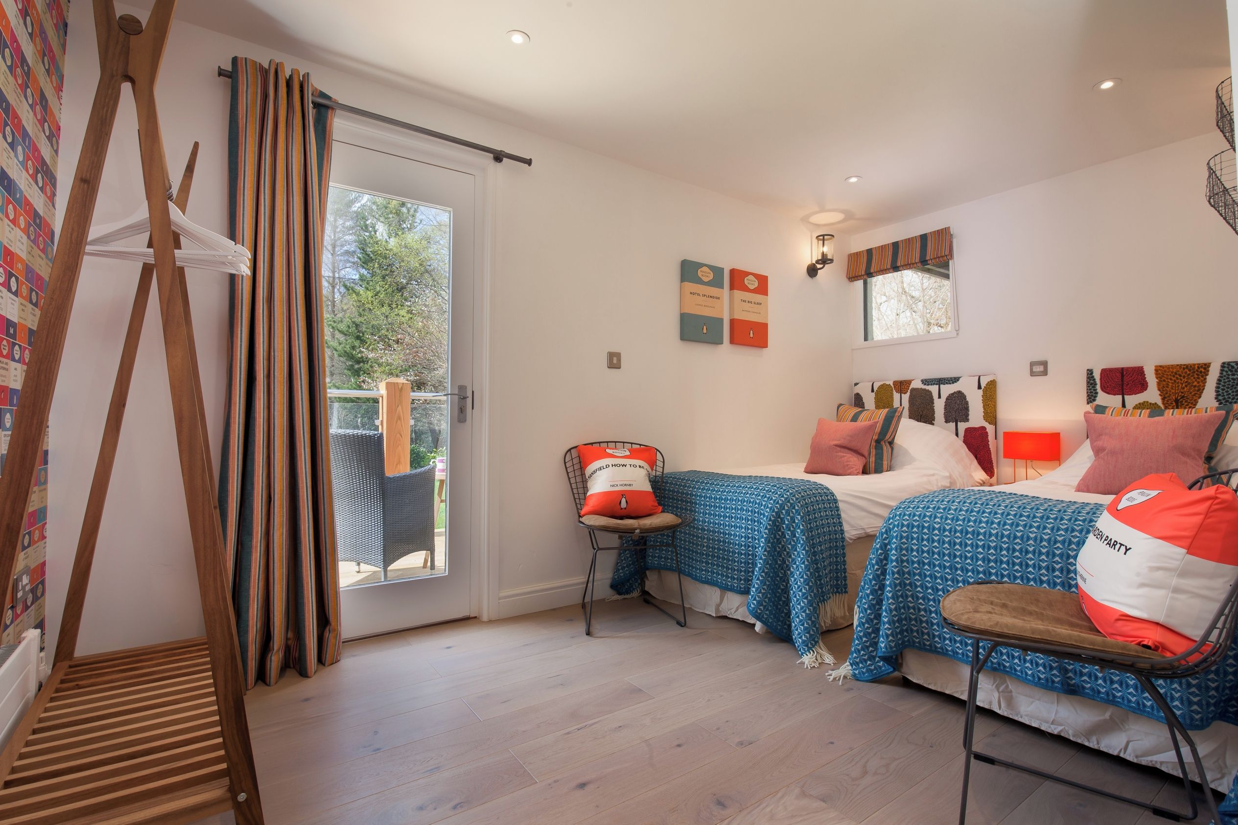 A bedroom with two beds, a window, a door, and a view of the outdoors.