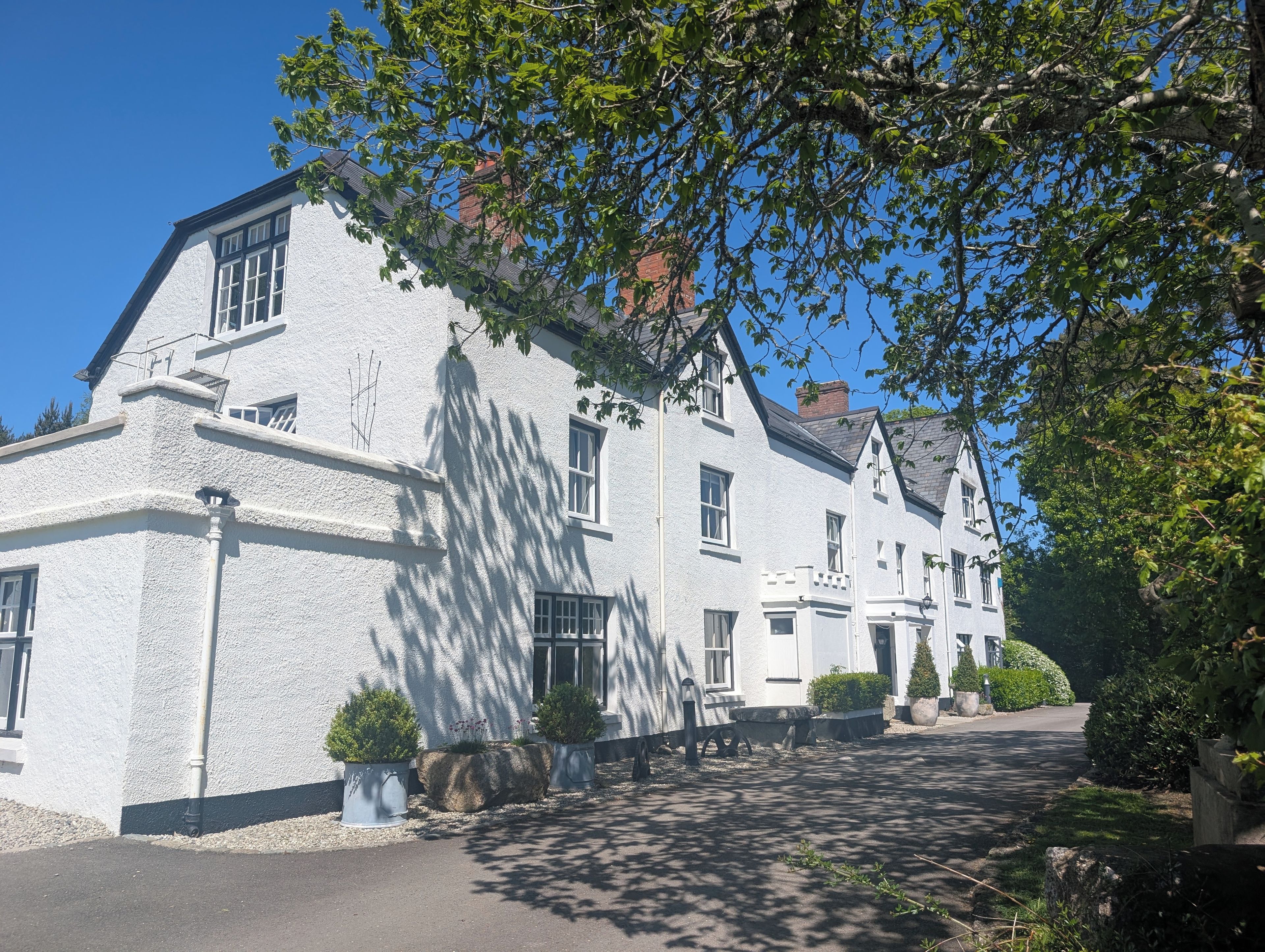 A white building with multiple windows and a paved driveway.