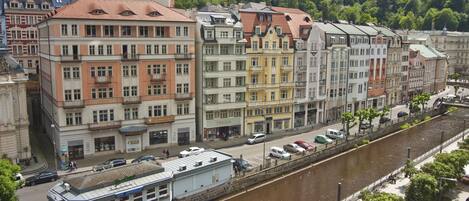 Vista del río de una ciudad histórica con edificios coloridos, un muelle y un paseo peatonal.