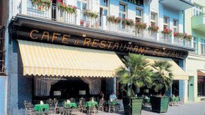 Un café doté d’une terrasse et d’une enseigne indiquant « CAFÉ-RESTAURANT ÉLÉGANT ».