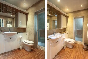 A modern bathroom with a shower, toilet, sink, and cabinets.