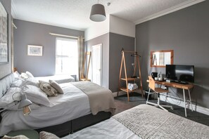 A bedroom with a bed, bedside table, lamp, and a desk with a chair and television. - Baytree Lodge (Chester)