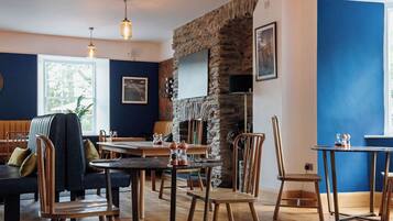 Un restaurante acogedor con mobiliario de madera, paredes de piedra e iluminación colgante.
