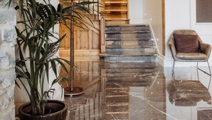 A spacious lobby with a marble floor, a staircase leading to upper levels, and a potted plant. - The Hafod Hotel (Aberystwyth)