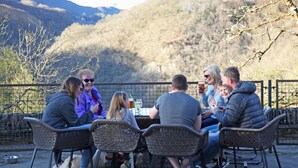 A group of people seated at a table outdoors with a mountainous backdrop. - The Hafod Hotel (Aberystwyth)