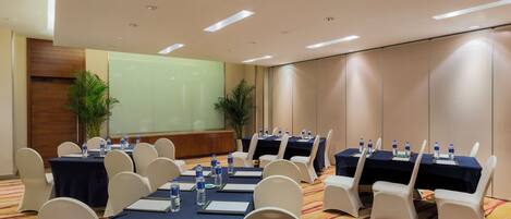 A conference room with tables set for meetings, equipped with water bottles and notepads.