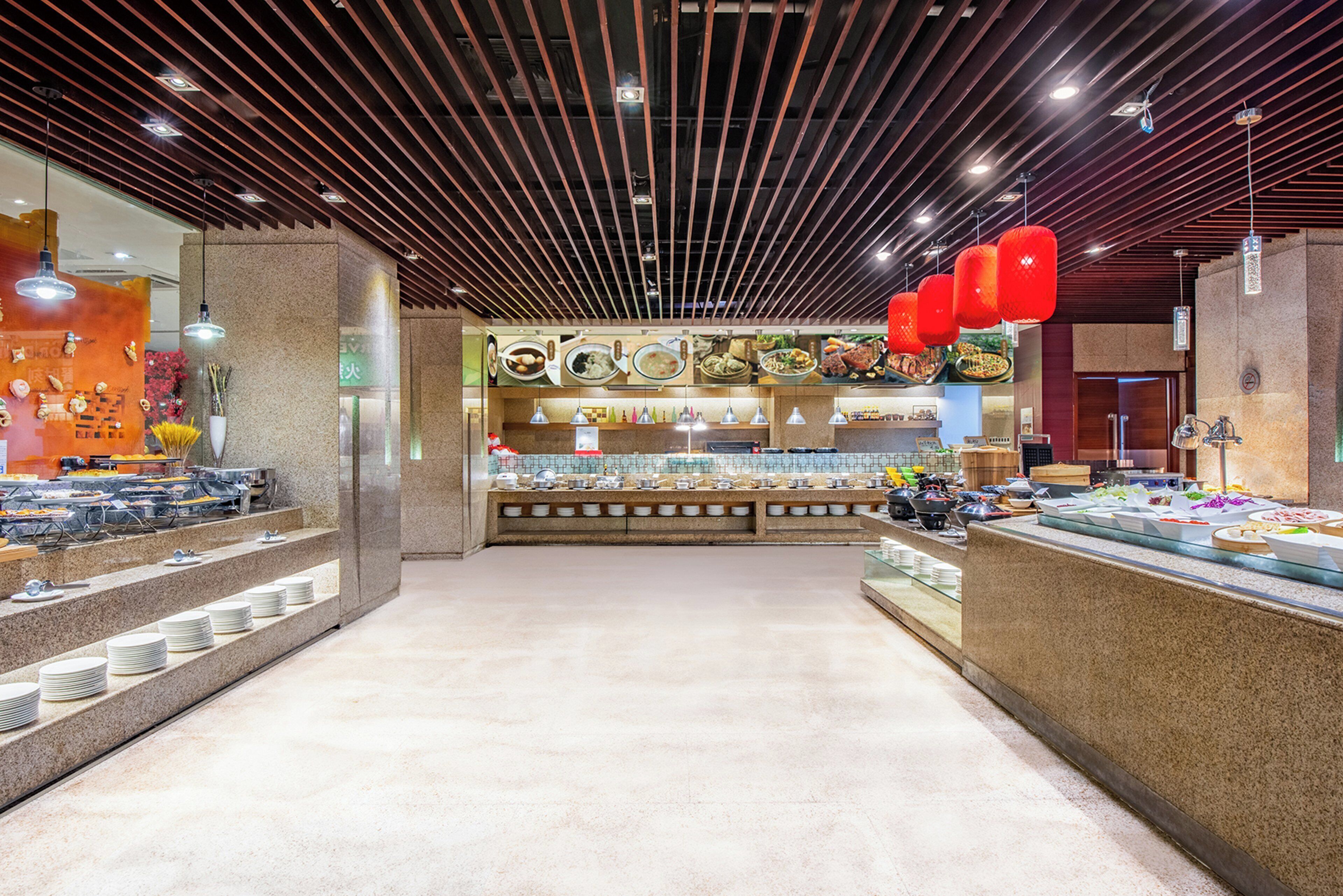 Zona de buffet con una variedad de alimentos y un mostrador con platos y cubiertos.
