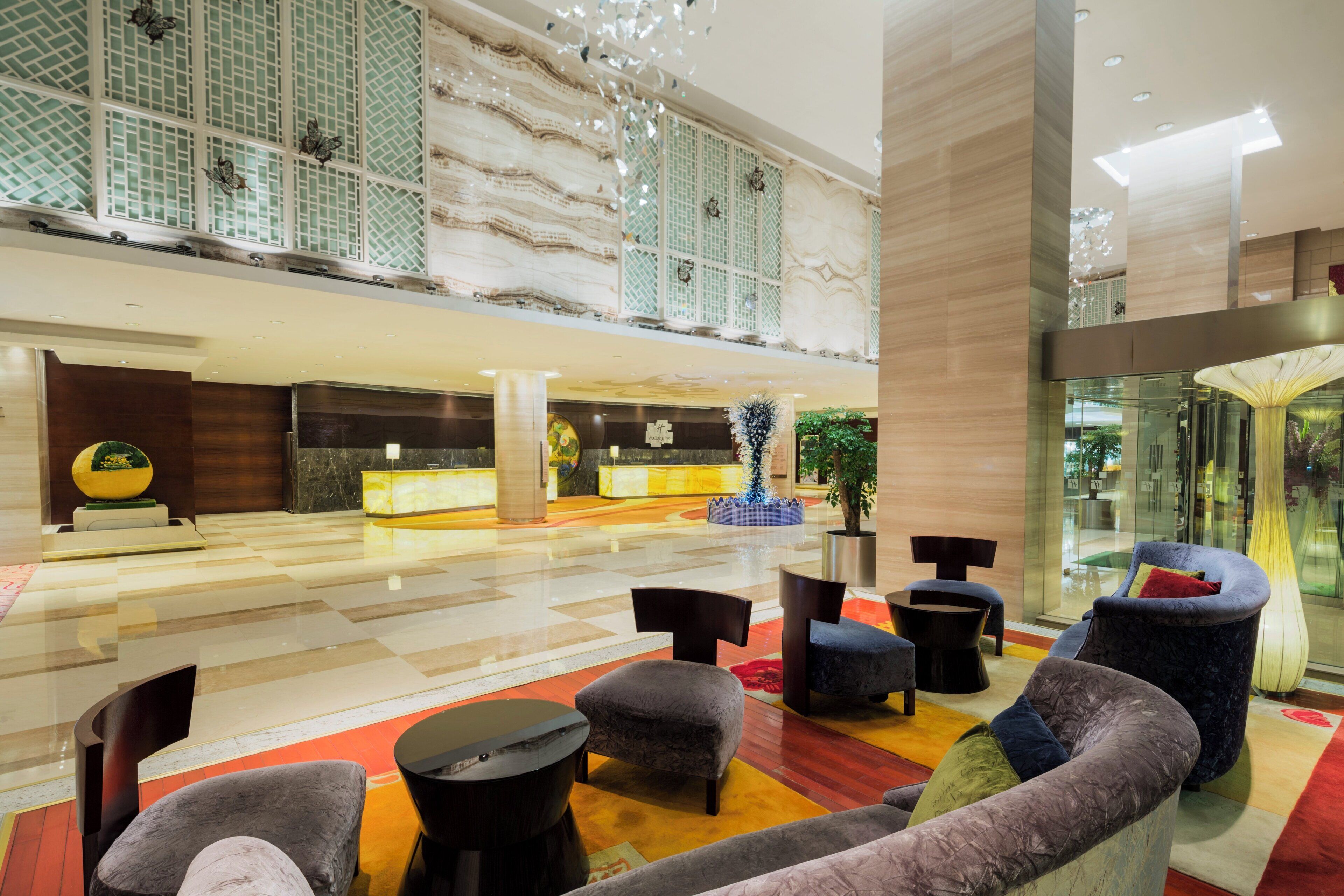 A spacious lobby with a reception desk, seating area, and decorative elements.