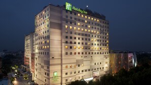 A multi-story Holiday Inn hotel with a modern design, featuring numerous windows and a prominent signage. - Holiday Inn Nanjing Aqua City by IHG (Nanjing)