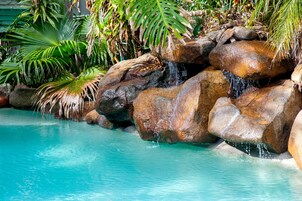 Una piscina al aire libre de temporada, sombrillas