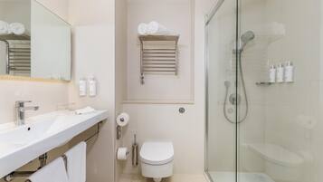 Une salle de bain moderne avec une douche à parois de verre, un lavabo blanc et des toilettes.