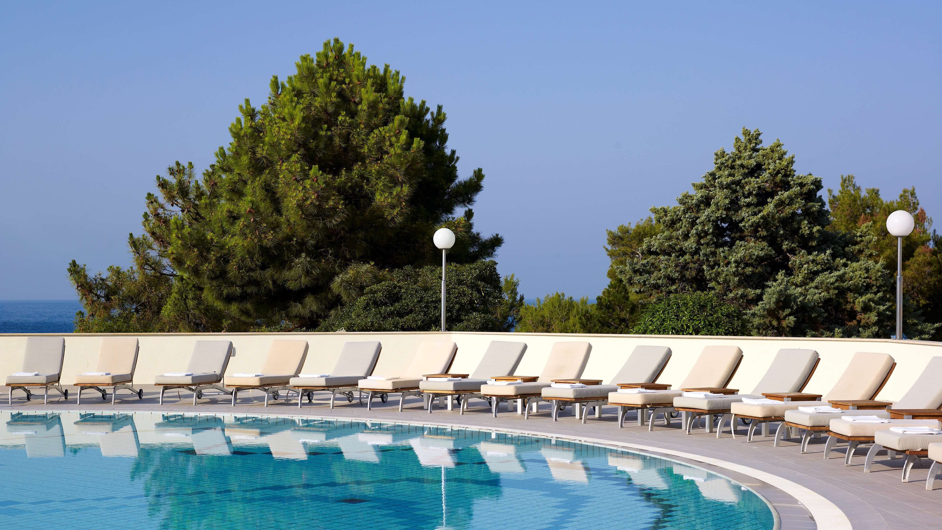 Una piscina techada, una piscina al aire libre de temporada, sombrillas