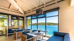 A modern outdoor seating area with a view of the sea, featuring wooden furniture and a large window. - Park Plaza Histria Pula (Pula)